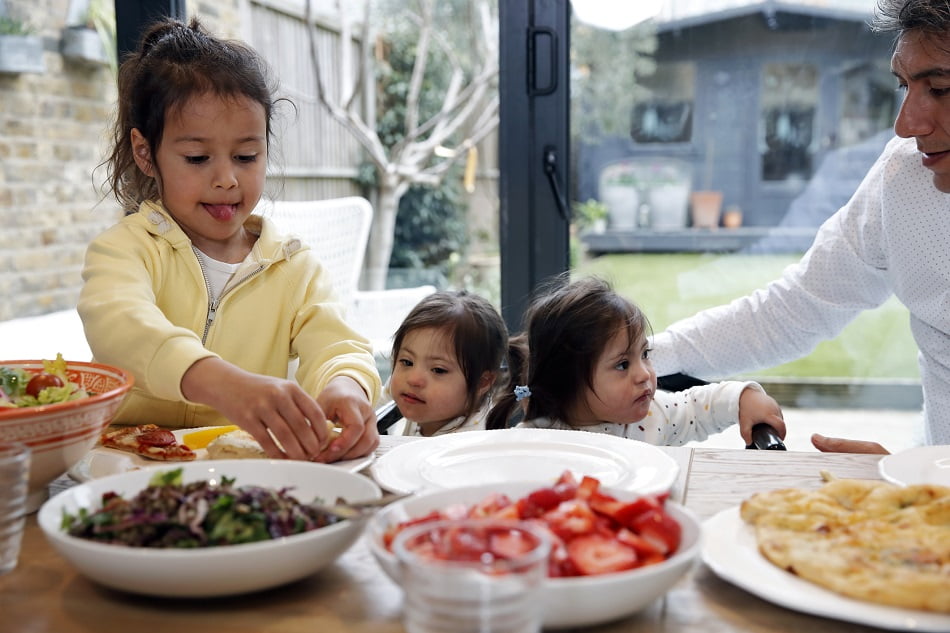 Mature father with daughters enjoying healthy lunch